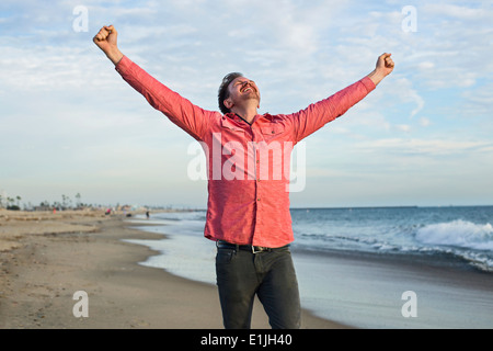 Young man celebrating on beach, Long Beach, California, USA Stock Photo