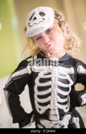Portrait of young girl in skeleton costume with skull mask Stock Photo