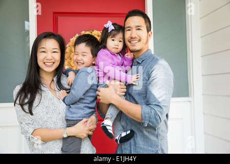 Portrait of mid adult couple and two young children on porch