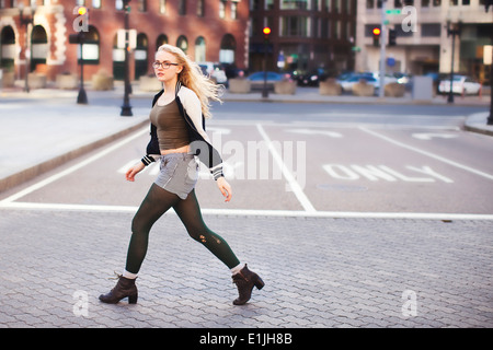 Young woman walking down street Stock Photo