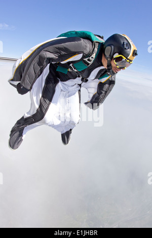 Mid adult man free falling in wingsuit preparing to fly Stock Photo