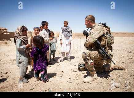 U.S. Army Staff Sgt. Matthew Parsons, assigned to Police Adviser Team Delaram, interacts with children in Delaram, Helmand prov Stock Photo