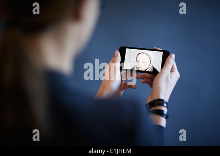 Working mother having video call with son on smartphone Stock Photo