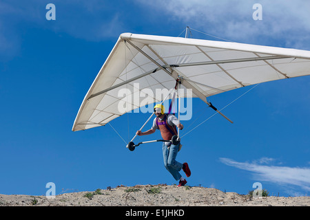 Hang glider pilot taking off Stock Photo