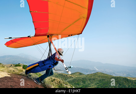 Hang glider pilot taking off Stock Photo