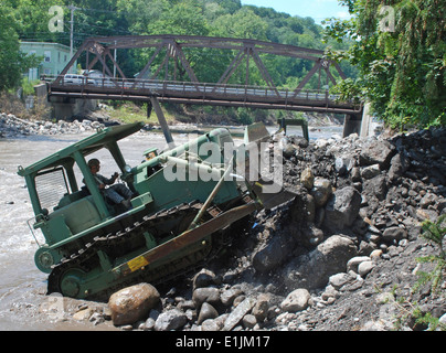 U.S. Army Pfc. Michael Bykowicz, with the 152nd Engineer Company, New York Army National Guard, removes rocks and other flood d Stock Photo