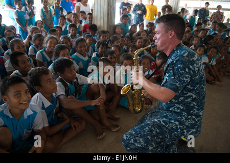 U.S. Navy Musician 1st Class Gresh Laing, right, performs for students during a community service project for Pacific Partnersh Stock Photo