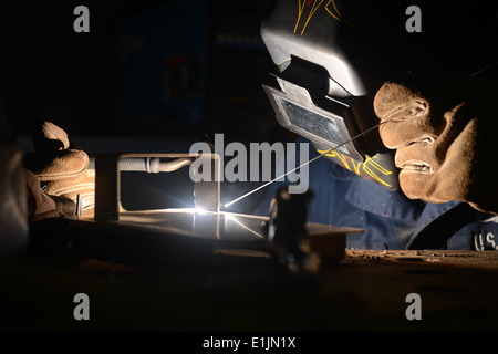 U.S. Navy Hull Maintenance Technician 2nd Class Neil Hopkins performs a welding procedure in the machine shop aboard the aircra Stock Photo