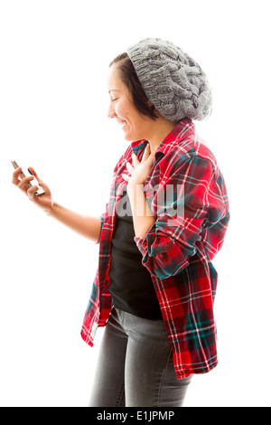 Young woman text messaging on mobile phone and looking surprised Stock Photo