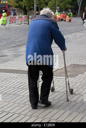 Elderly man walking with the aid of a frame, London Stock Photo
