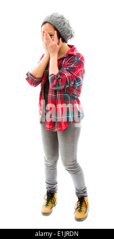 Young woman peeking through hands covering face Stock Photo