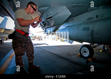 U.S. Air Force Tech. Sgt. Jason Wagner adjusts a BRU-42 triple ejector rack on an F-16C Fighting Falcon, Oct. 18, 2013 at Atlan Stock Photo