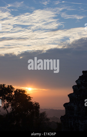 Sunrise at Phnom Bakheng, a temple located atop a hill in Angkor, Cambodia. Phnom Bakheng is also a popular tourist sunset spot. Stock Photo