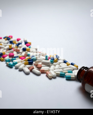 Pills spilling out of bottle Stock Photo