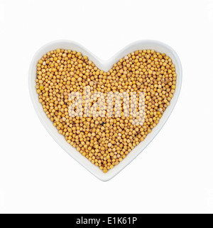 Mustard seeds in a heart-shaped dish. Stock Photo