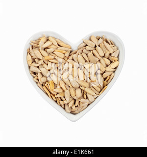 Shelled sunflower seeds in a heart-shaped dish. Stock Photo