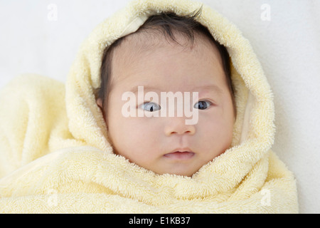 MODEL RELEASED Baby girl wrapped in a towel portrait. Stock Photo