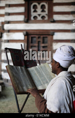 Priest reading a Bible at St. Yimrhane Kristos cave church Stock Photo