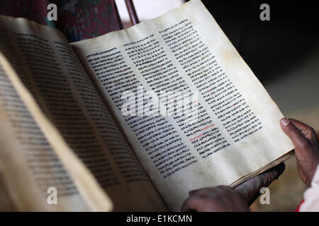 Priest reading a Bible at St. Yimrhane Kristos cave church Stock Photo