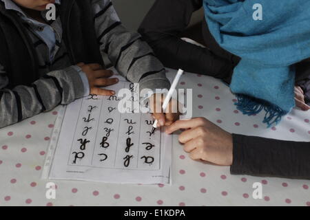 6-year-old boy writing with his sister Stock Photo