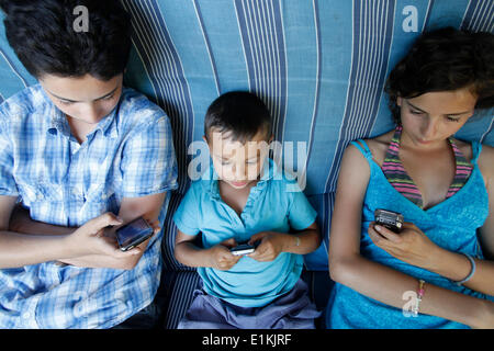 Children playing games on mobile phones Stock Photo