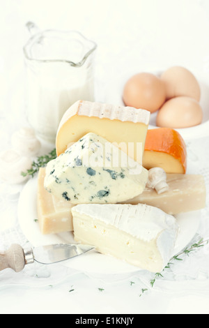 Cheese, fresh brown eggs and milk on a white linen Stock Photo