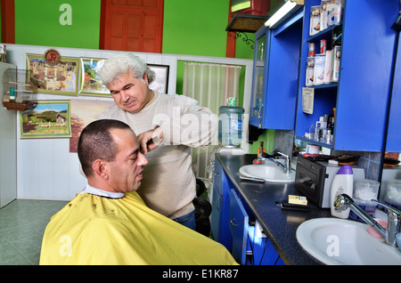 Barber with a client, Lefka, Northern Cyprus Stock Photo