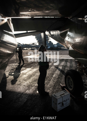 U.S. Navy Aviation Electronics Technician Airman Alison Guzik checks the exhaust of an E-2C Hawkeye aircraft assigned to Carrie Stock Photo