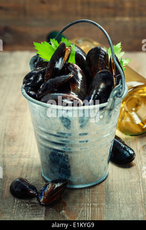 Fresh mussels ready for cooking on wooden background Stock Photo