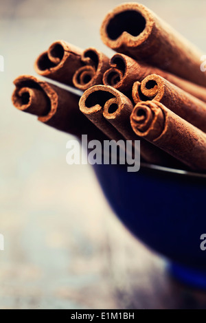 Bunch of cinnamon sticks in blue bowl Stock Photo