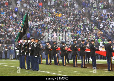 U.S. Army color guard members assigned to the 4th Stryker Brigade Combat Team, 2nd Infantry Division perform during a football Stock Photo