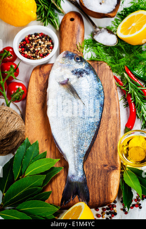 fresh dorado fish and vegetables on wooden board - food and drink Stock Photo