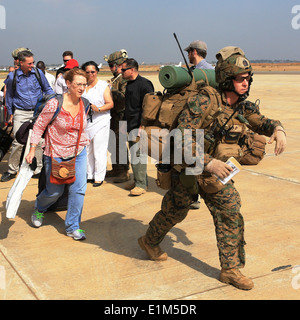 A U.S. Marine, right, assigned to Special Purpose Marine Air-Ground Task Force Crisis Response, guides U.S. citizens on a fligh Stock Photo