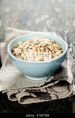 Rolled oats in a bowl on wooden board Stock Photo