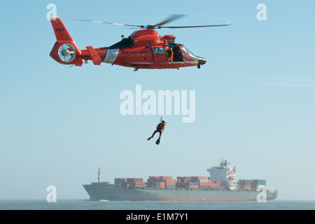 U.S. Coast Guard Petty Officer 3rd Class Andrew Wilson, a rescue swimmer with Air Station Houston, dangles from an HH-65 Dolphi Stock Photo