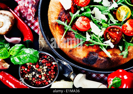 pizza and fresh italian ingredients on a dark background Stock Photo