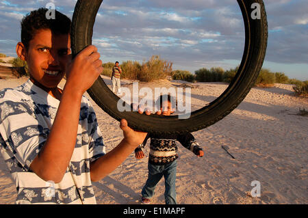 Children playing with an old tyre Stock Photo