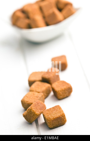 brown sugar cubes on white wooden table Stock Photo