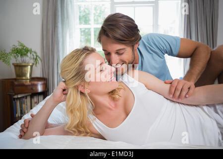 Cute couple relaxing on bed about to kiss Stock Photo