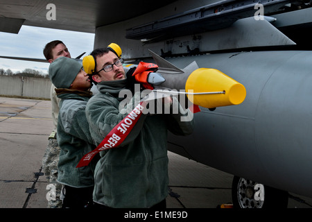 U.S. Airmen with a weapons load crew with the 48th Air Expeditionary Group mount an AIM-9X Sidewinder missile onto an F-15C Eag Stock Photo