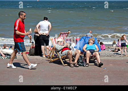 Elderly couple sunbathing in British seaside resort Stock Photo