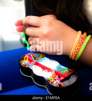 Young woman make rubber band bracelet with a loom Stock Photo - Alamy