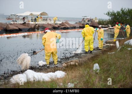 Responders work to clean up oil with pom-poms and rakes from some of the worst-hit areas of Galveston Island in Texas April 3, Stock Photo