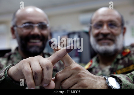 An Afghan National Army lieutenant colonel, left, and a major, both with the 201st Corps, display the blue ink on their fingers Stock Photo