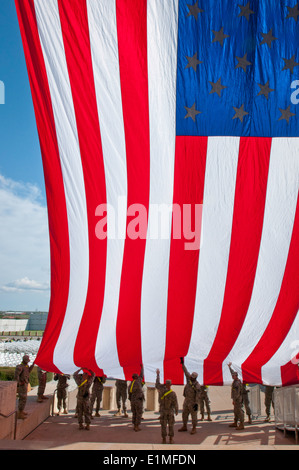 U.S. Soldiers with the 1st Cavalry Division hang an American flag from the III Corps headquarters at Fort Hood, Texas, April 7, Stock Photo