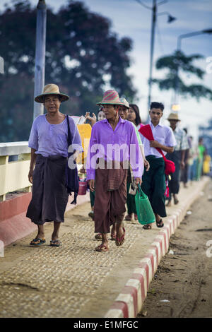 June 6, 2014 - Pantanaw, Ayeyarwady Region, Myanmar - Burmese walk into Pantanaw, a town in the Irrawaddy Delta (or Ayeyarwady Delta) in Myanmar. The region is Myanmar's largest rice producer, so its infrastructure of road transportation has been greatly developed during the 1990s and 2000s. Two thirds of the total arable land is under rice cultivation with a yield of about 2,000-2,500 kg per hectare. FIshing and aquaculture are also important economically. Because of the number of rivers and canals that crisscross the Delta, steamship service is widely available. (Credit Image: © Jack Kurtz/Z Stock Photo