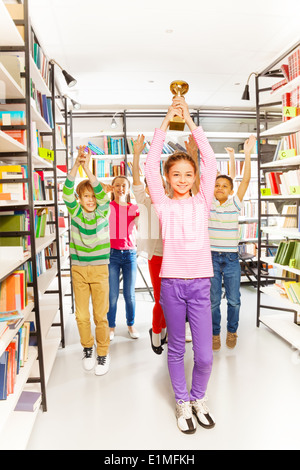 Happy girl holds cup and kids jumping behind Stock Photo