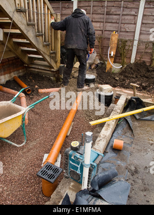 self building house, backfilling drainage channels with pea gravel around pipes being connected to gullies Stock Photo