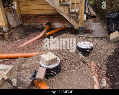 self building house, backfilling drainage channels with pea gravel around pipes being connected to gullies Stock Photo