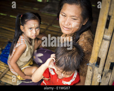 June 6, 2014 - Pantanaw, Ayeyarwady Region, Myanmar - A woman with her children in their home in the Irrawaddy Delta (or Ayeyarwady Delta) in Myanmar. The region is Myanmar's largest rice producer, so its infrastructure of road transportation has been greatly developed during the 1990s and 2000s. Two thirds of the total arable land is under rice cultivation with a yield of about 2,000-2,500 kg per hectare. FIshing and aquaculture are also important economically. Because of the number of rivers and canals that crisscross the Delta, steamship service is widely available. (Credit Image: © Jack Ku Stock Photo